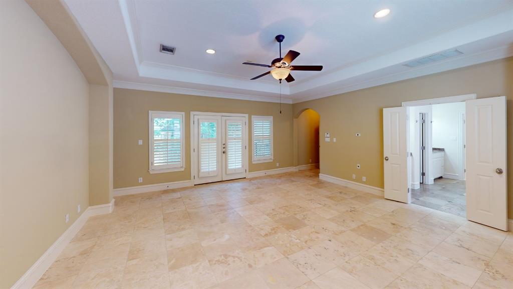 4516 Gilbert Avenue Dallas, TX 75219 - Photo 8 of 28 Spacious room featuring light-toned tile flooring, a tray ceiling with recessed lighting, and a ceiling fan