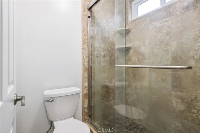 a bathroom with a toilet and a shower