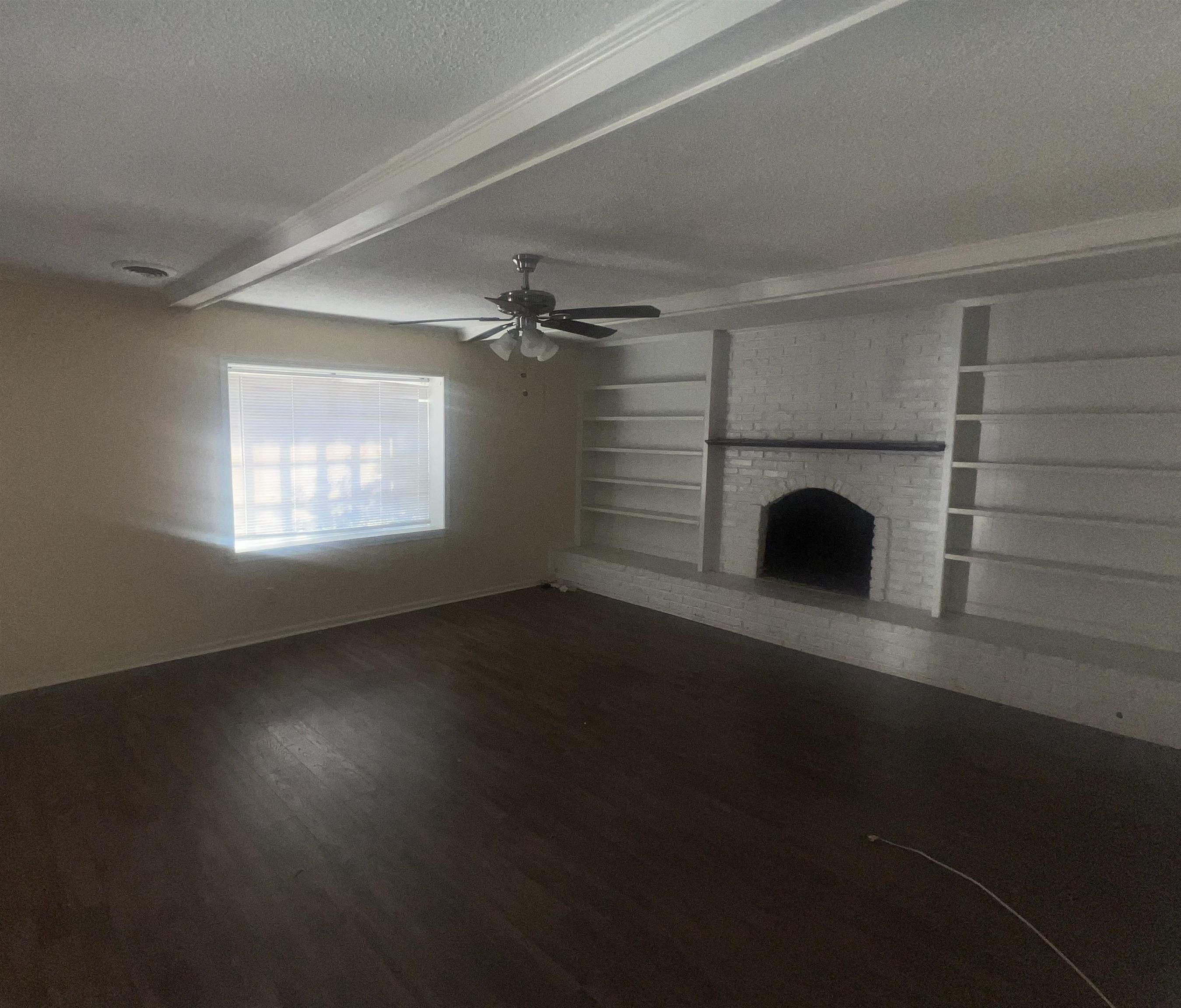 4295 Hudgins Road Memphis, TN 38116 - Photo 7 of 16 Spacious interior featuring wood-finish flooring, a ceiling fan, and a wide window with blinds