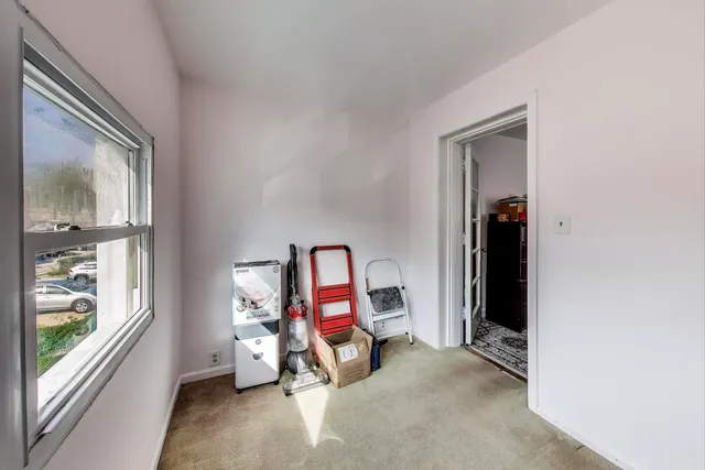 a view of a workspace with furniture and a window