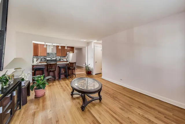 a kitchen with stainless steel appliances granite countertop a stove a refrigerator a sink a dining table and chairs