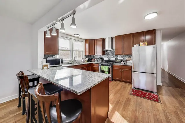 a kitchen with stainless steel appliances granite countertop a refrigerator stove and sink