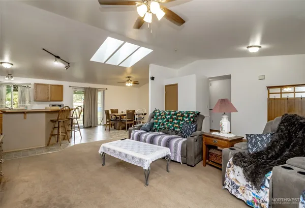 a kitchen with stainless steel appliances a refrigerator a stove a sink a dining table and chairs