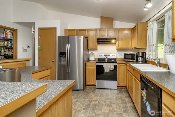 a kitchen with stainless steel appliances granite countertop a stove a sink dishwasher and a refrigerator