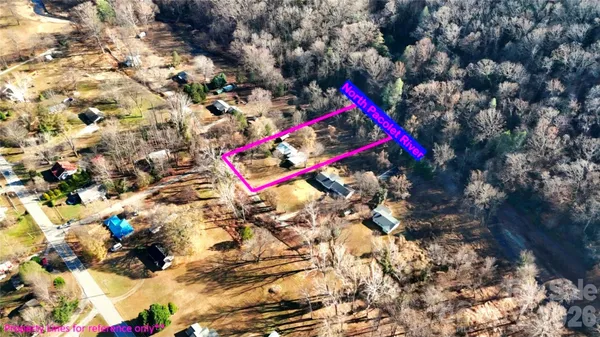 a view of house with yard and trees in the background