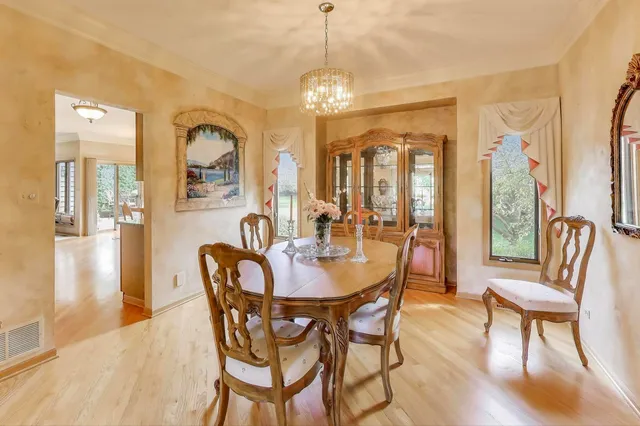 a dining room with furniture a chandelier and wooden floor
