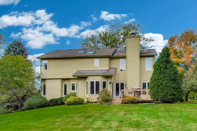 a front view of a house with a yard and potted plants