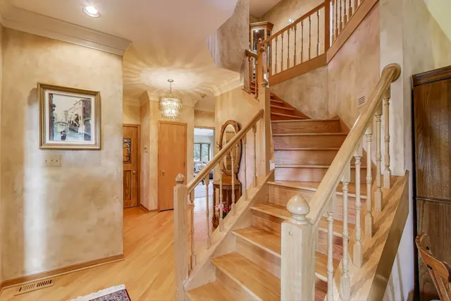 a view of staircase with lots of frames on wall and wooden floor