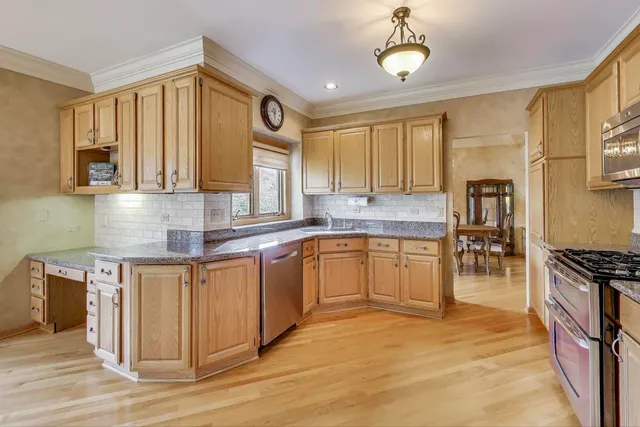 a kitchen with stainless steel appliances granite countertop a stove a sink and a refrigerator