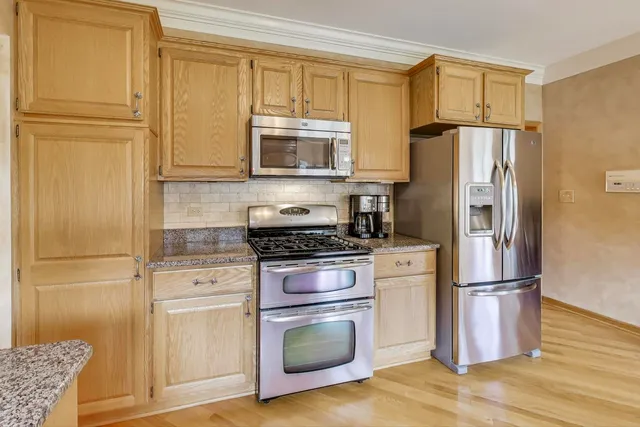 a kitchen with stainless steel appliances granite countertop a refrigerator microwave and sink