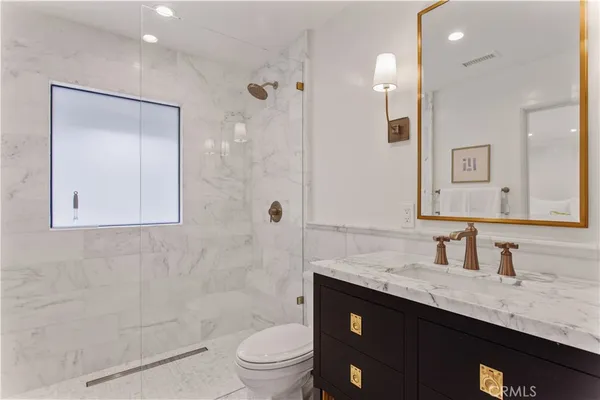 a bathroom with a granite countertop sink toilet and shower