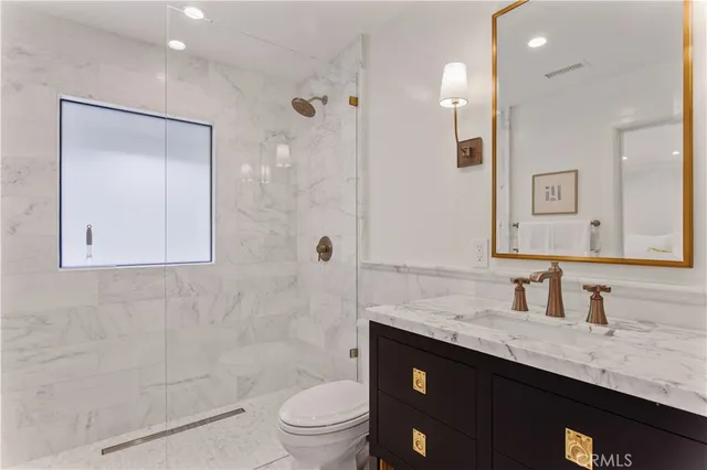 a bathroom with a granite countertop sink toilet and shower