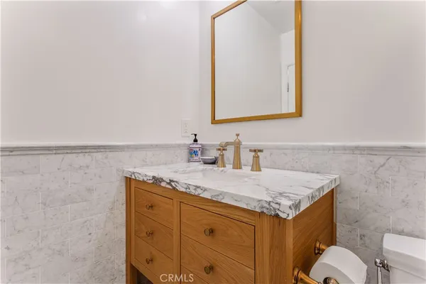 a bathroom with a granite countertop sink toilet mirror vanity and shower