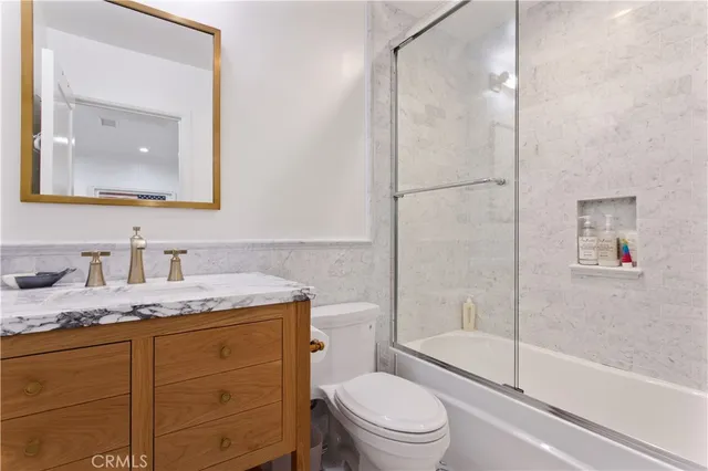 a backyard of a house with lawn chairs plants and wooden fence