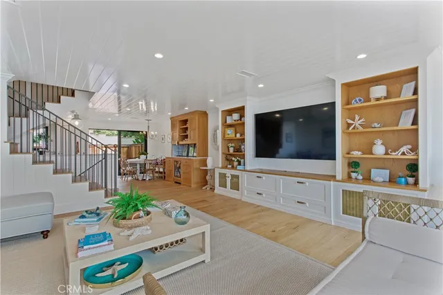 a living room with furniture kitchen view and a flat screen tv