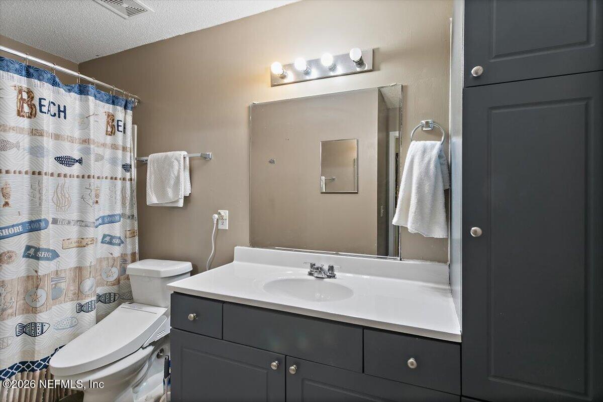 10200 Belle Rive Boulevard, Unit 66 Jacksonville, FL 32256 - Photo 13 of 18 a bathroom with a sink toilet a shower and a mirror