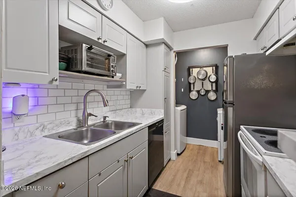 a kitchen with stainless steel appliances granite countertop a sink stove and microwave