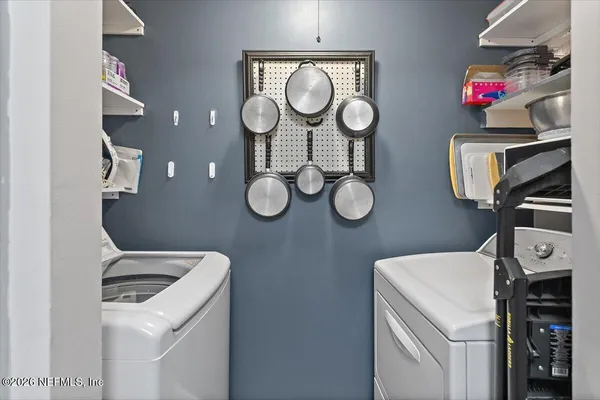 a view of a storage and utility room with washer and dryer
