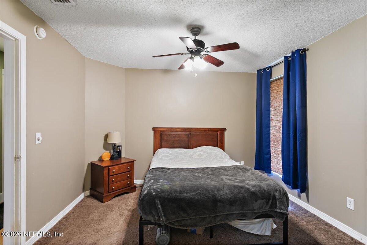 10200 Belle Rive Boulevard, Unit 66 Jacksonville, FL 32256 - Photo 9 of 18 a bedroom with a bed and a chandelier
