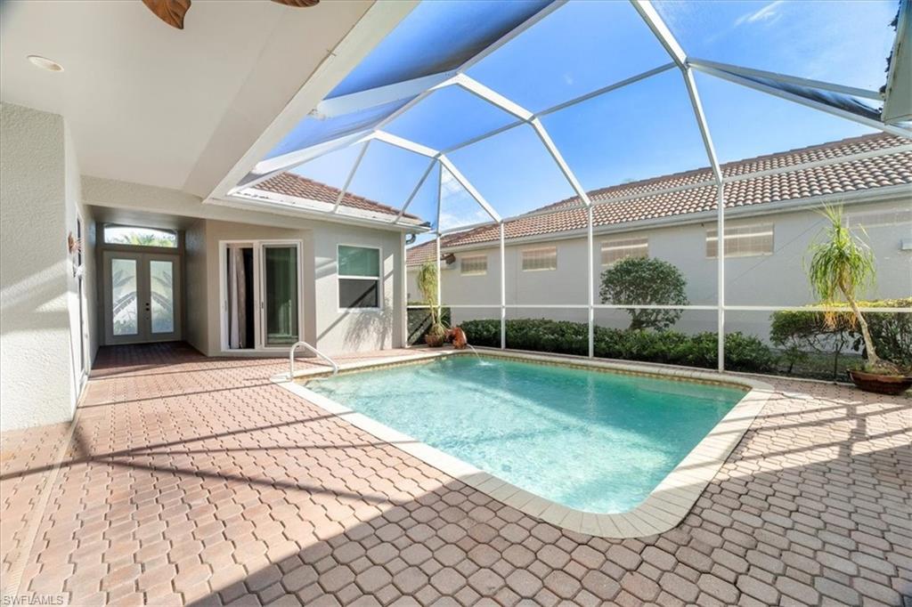View of pool featuring french doors, a patio, glass enclosure, and ceiling fan