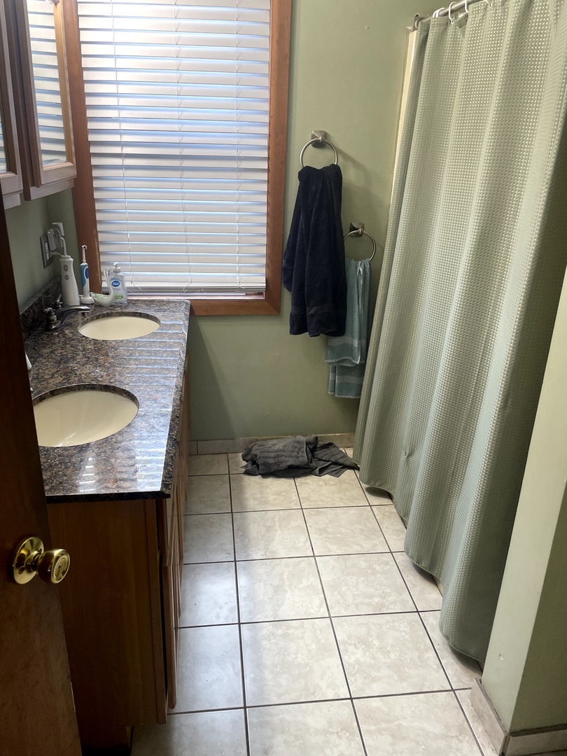 9803 West 57th Street Countryside, IL 60525 - Photo 7 of 13 a bathroom with a granite countertop sink and a mirror
