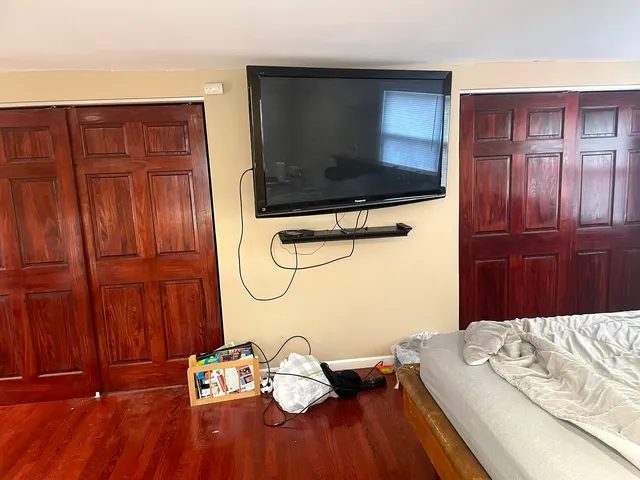 a bed sitting in a bedroom and wooden floor