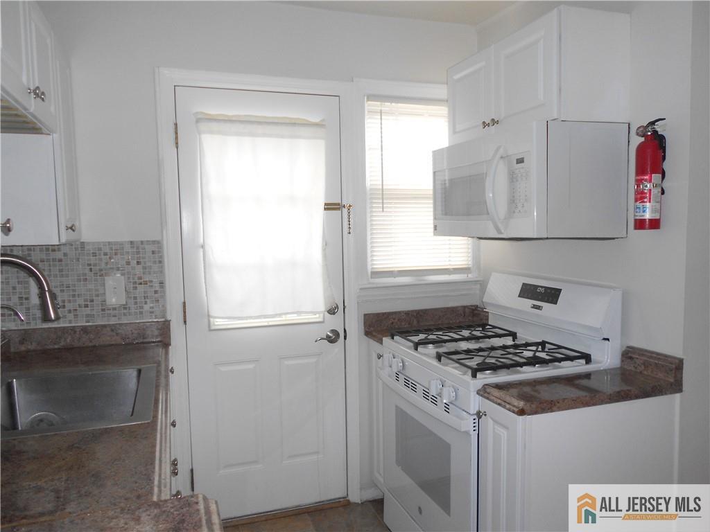 431 Crows Mill Road Fords, NJ 08863 - Photo 7 of 20 a white kitchen with sink stove and cabinets