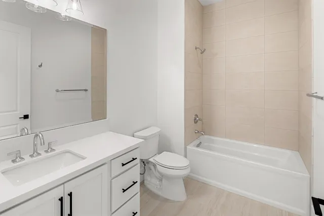 a bathroom with a granite countertop sink a toilet and shower