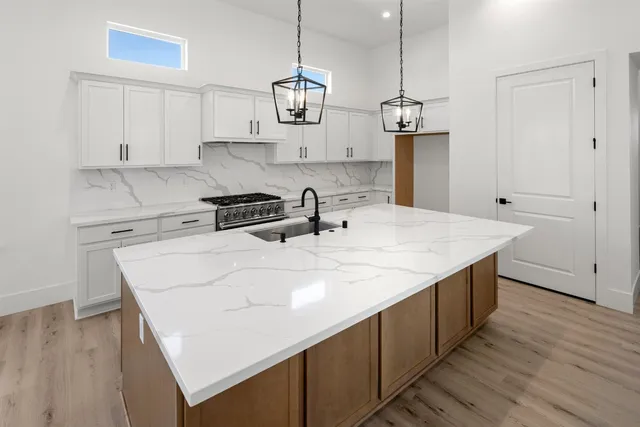 a kitchen with a sink a stove and chairs