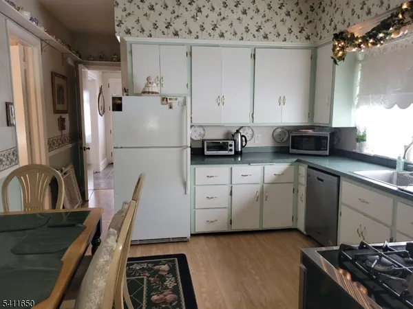 a kitchen with white cabinets and appliances