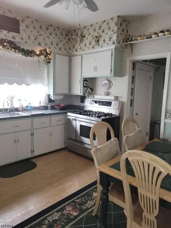 a kitchen with stainless steel appliances granite countertop a stove a sink and white cabinets