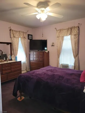 a bedroom with a bed and a flat tv screen on the dresser
