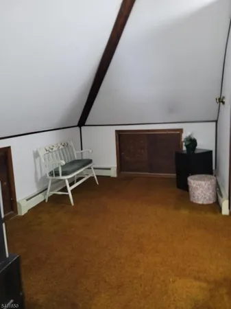 a view of an empty room with wooden floor and windows