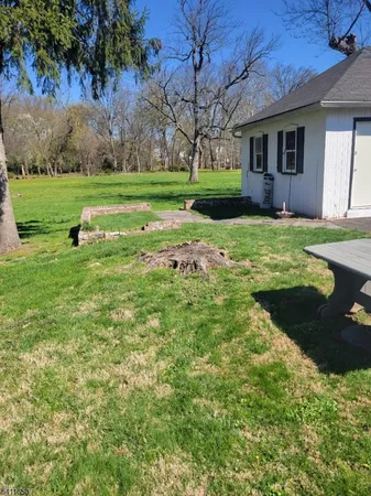 a view of a house with a yard and pathway