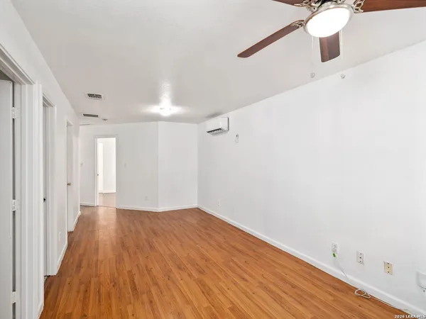 a view of an empty room with wooden floor