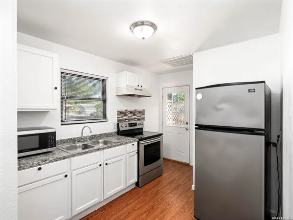 a kitchen with a refrigerator and a stove top oven