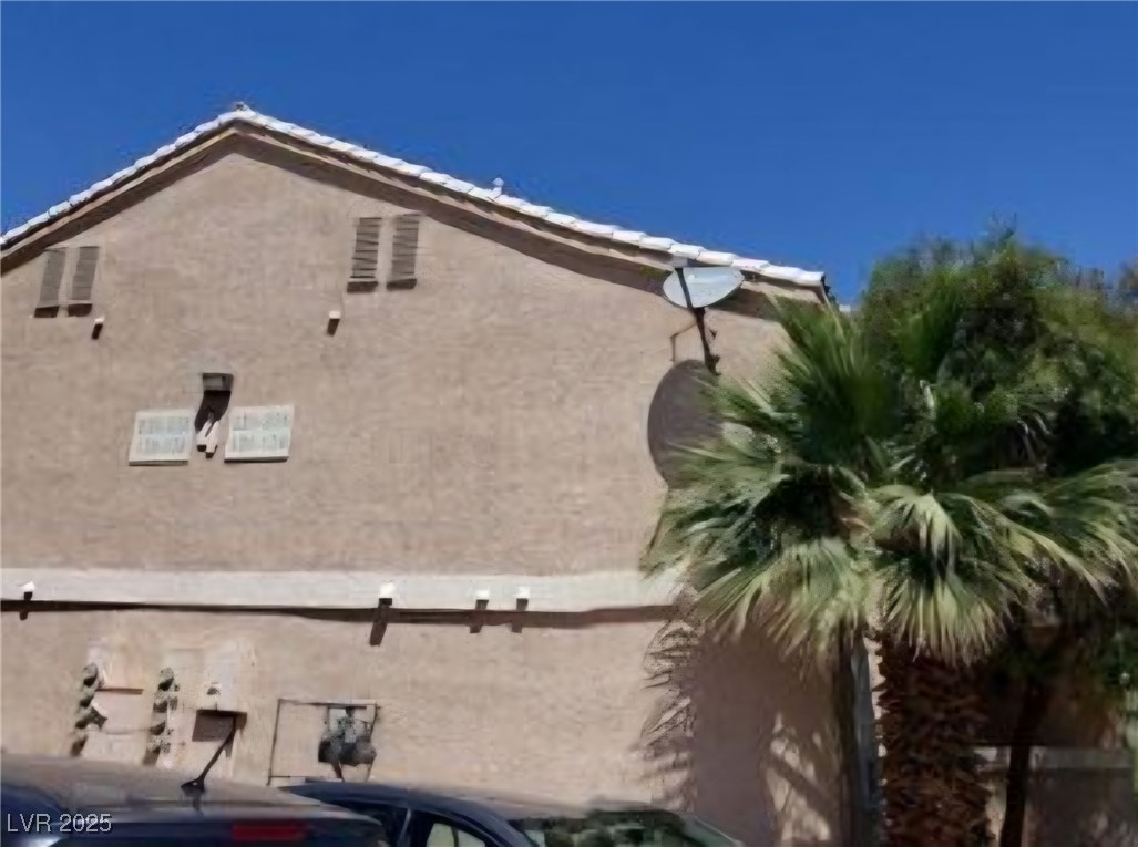 1830 North Pecos Road, Unit 131 Las Vegas, NV 89115 - Photo 2 of 13 View of property exterior featuring a tiled roof and stucco siding
