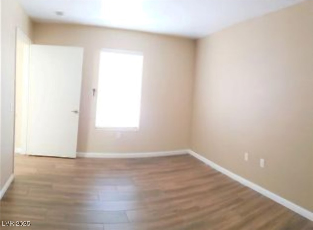 1830 North Pecos Road, Unit 131 Las Vegas, NV 89115 - Photo 9 of 13 Empty room featuring wood finished floors and baseboards