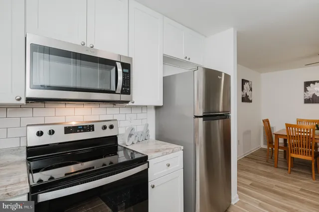 a kitchen with appliances and wooden floor