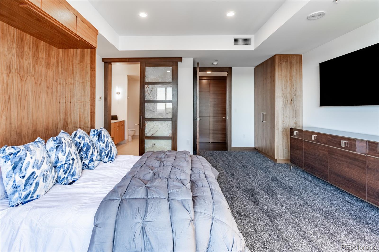 1133 14th Street, Unit 2620 Denver, CO 80202 - Photo 28 of 43 a bedroom with a large bed and a flat screen tv