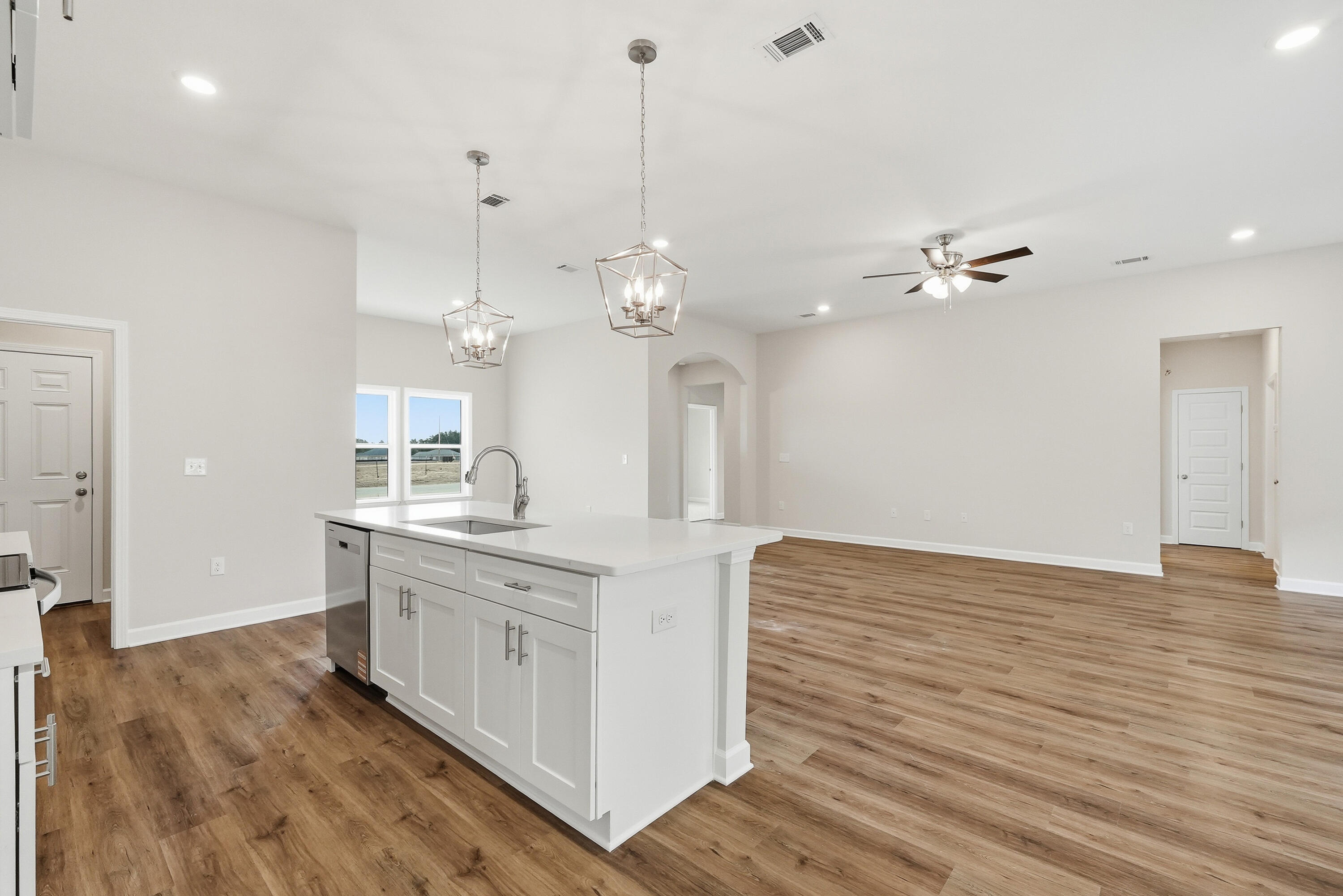 6106 Mildred's Way Crestview, FL 32539 - Photo 11 of 31 a view of a kitchen counter space a sink wooden floor and a chandelier