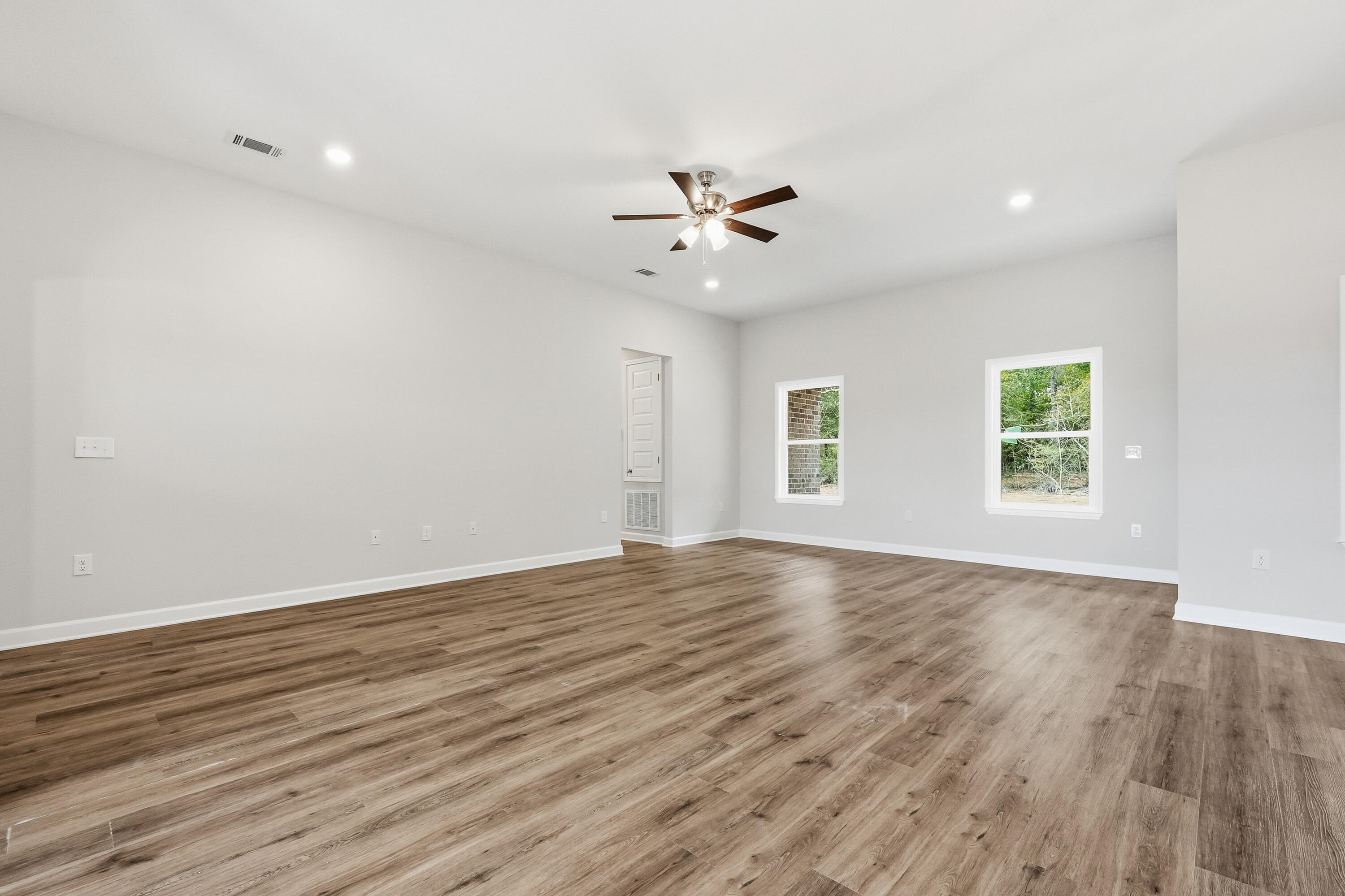 6106 Mildred's Way Crestview, FL 32539 - Photo 6 of 31 an empty room with wooden floor and windows