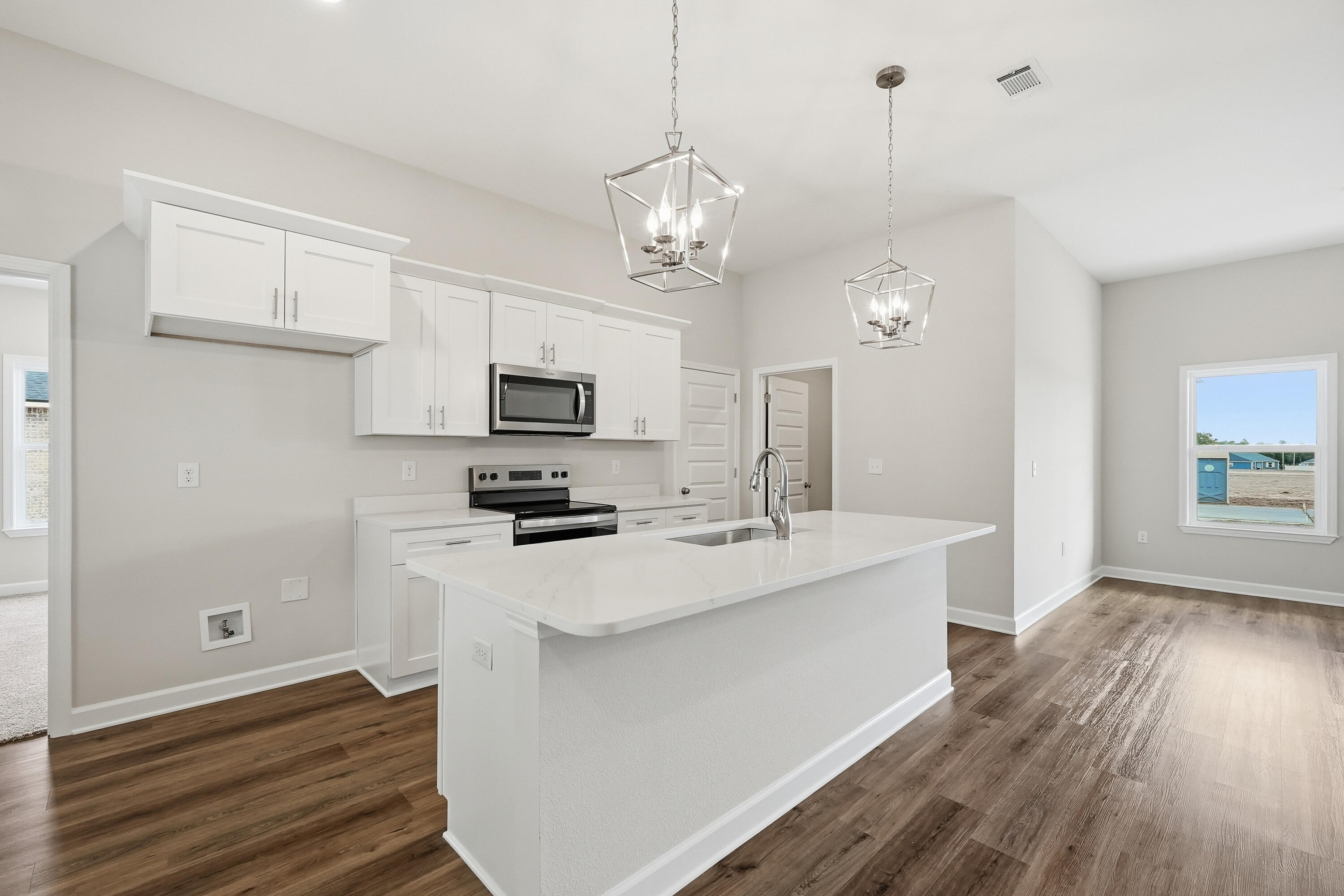 6106 Mildred's Way Crestview, FL 32539 - Photo 8 of 31 a kitchen with stainless steel appliances a stove a sink dishwasher a refrigerator white cabinets and wooden floor