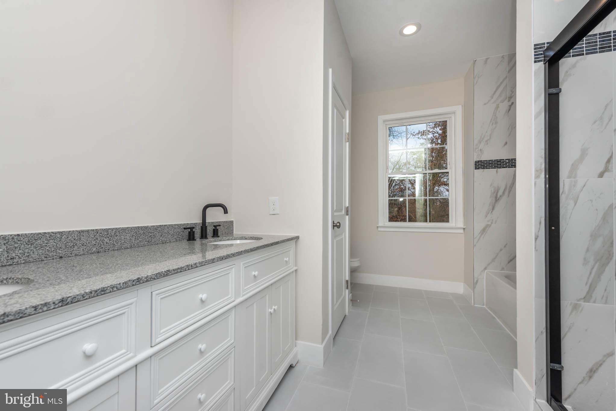 9626 Harford Road Parkville, MD 21234 - Photo 14 of 33 a bathroom with a granite countertop sink a mirror and next to a window