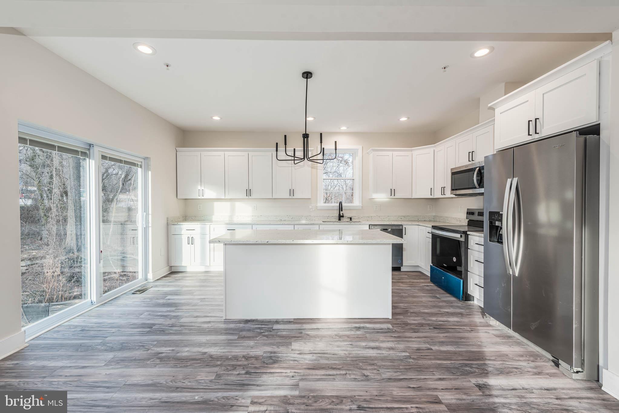 9626 Harford Road Parkville, MD 21234 - Photo 7 of 33 a kitchen with kitchen island white cabinets and stainless steel appliances