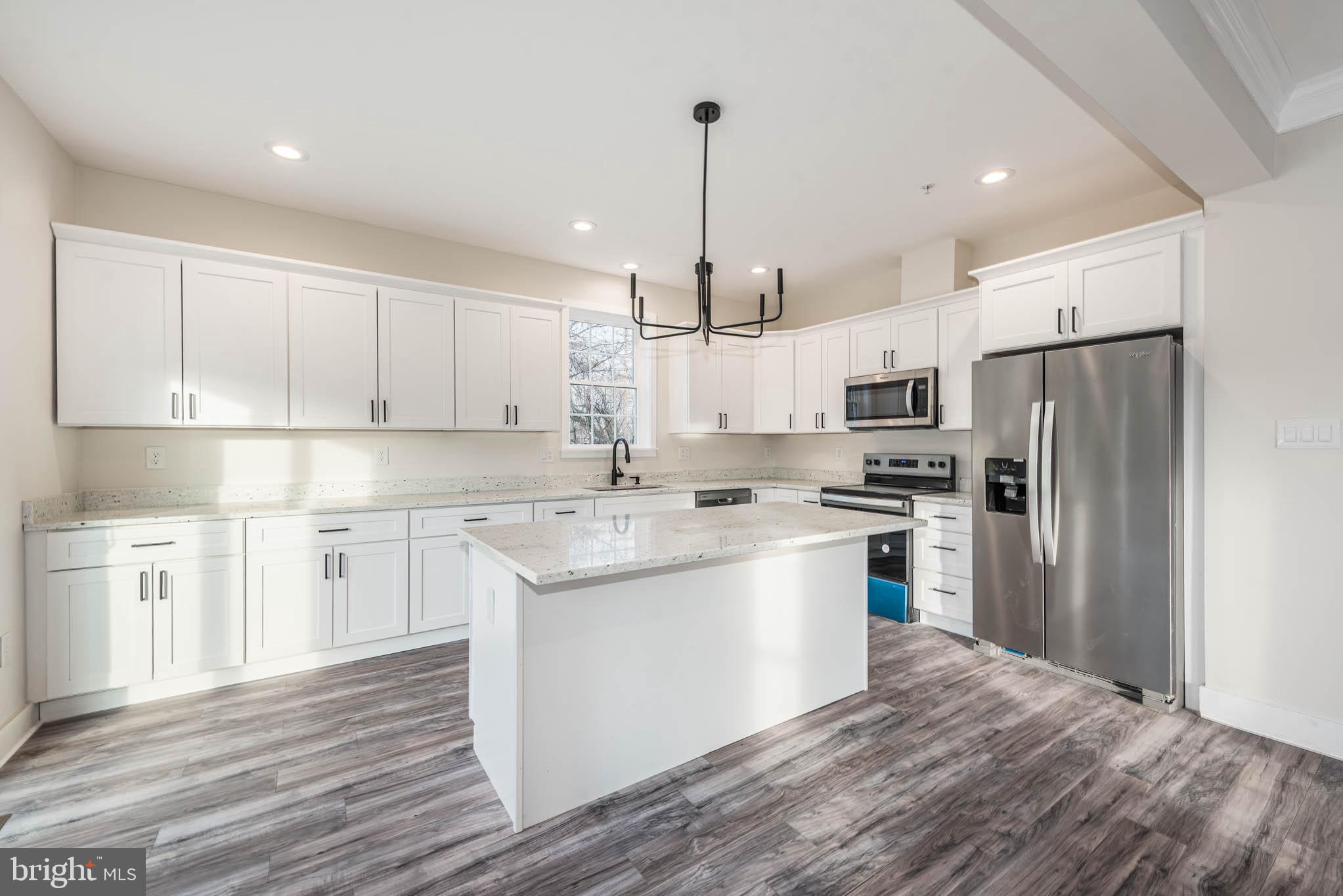 9626 Harford Road Parkville, MD 21234 - Photo 8 of 33 a kitchen with stainless steel appliances granite countertop a refrigerator a sink dishwasher a stove and white cabinets with wooden floor