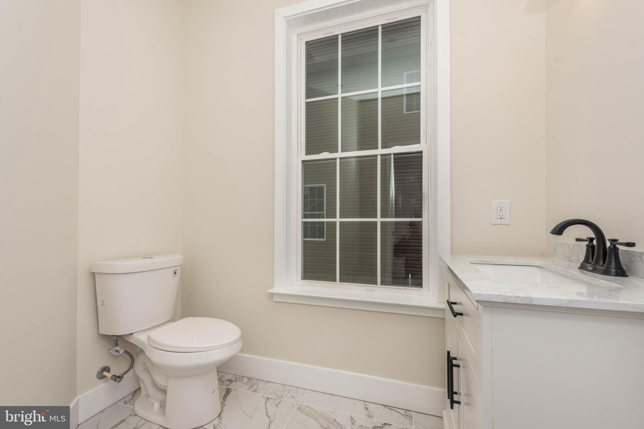 9626 Harford Road Parkville, MD 21234 - Photo 10 of 33 a bathroom with a sink a toilet and a window