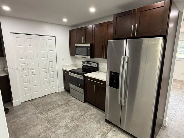 a view of a refrigerator in kitchen and windows