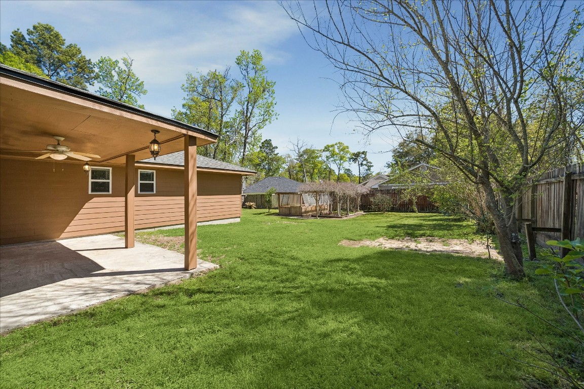 25732 Chestnut Lane Splendora, TX 77372 - Photo 24 of 27 Backyard with covered patio and views of the greenhouse and garden area.