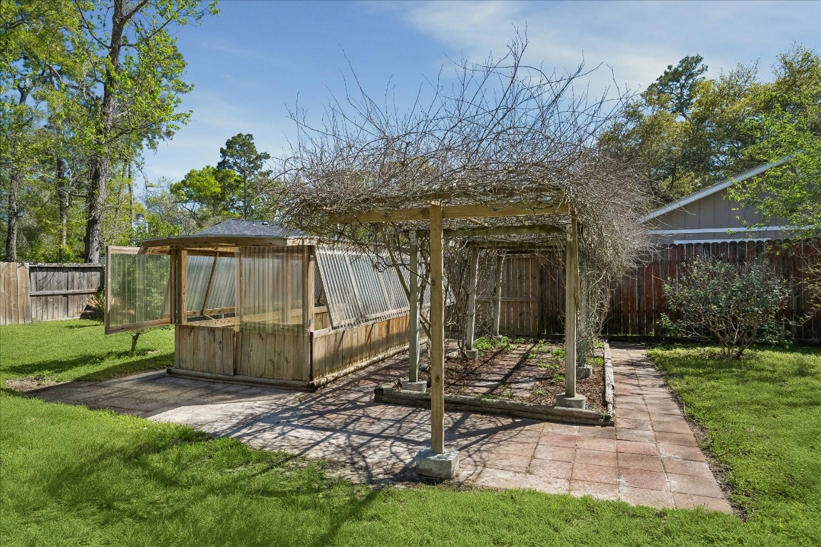 25732 Chestnut Lane Splendora, TX 77372 - Photo 25 of 27 Garden area with pergola, perfect for outdoor seating or planting.